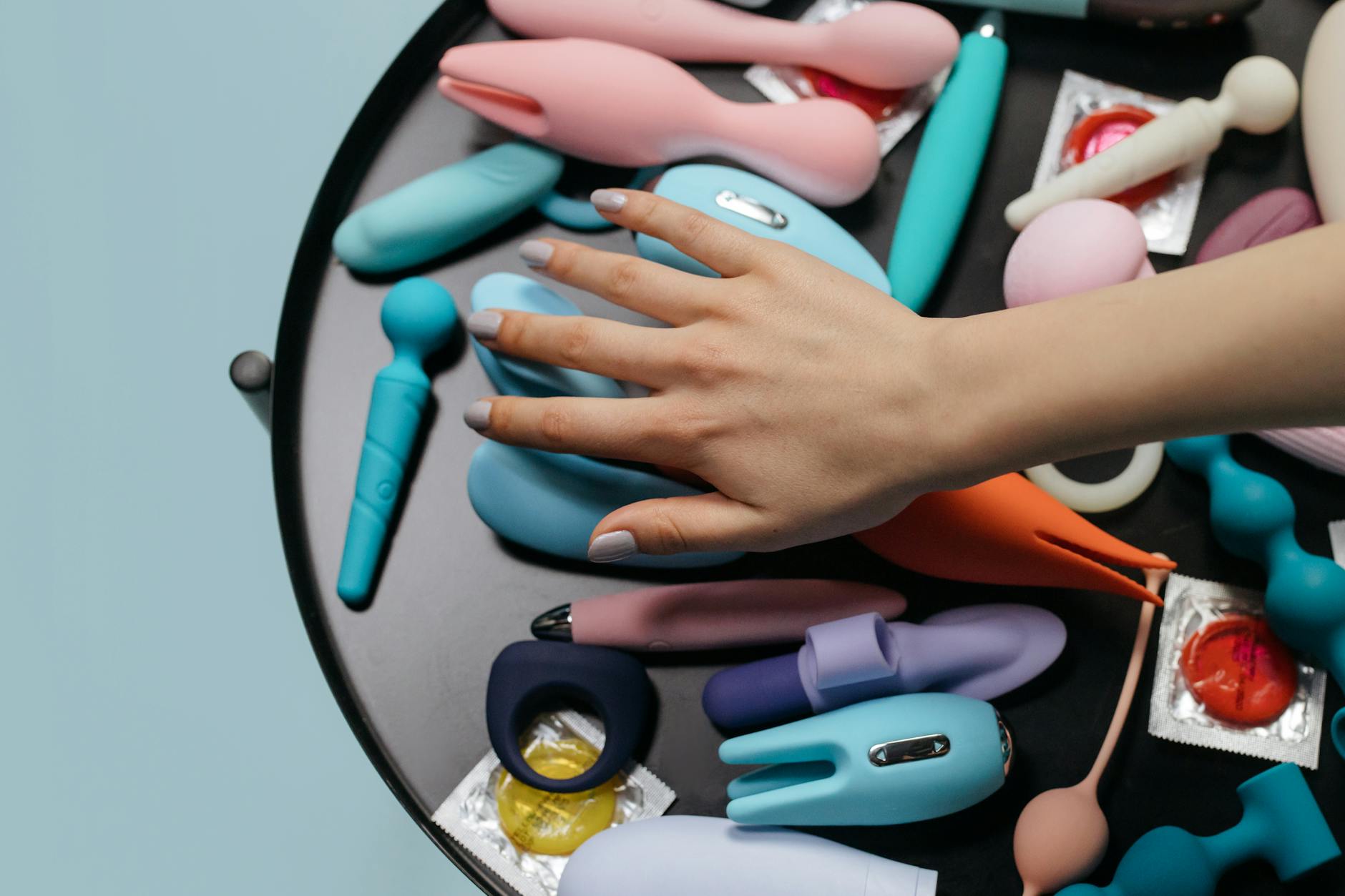 Una coppia di coppie che tengono un vibratore colorato su un tavolo, simboleggiando l'esplorazione moderna dell'intimità