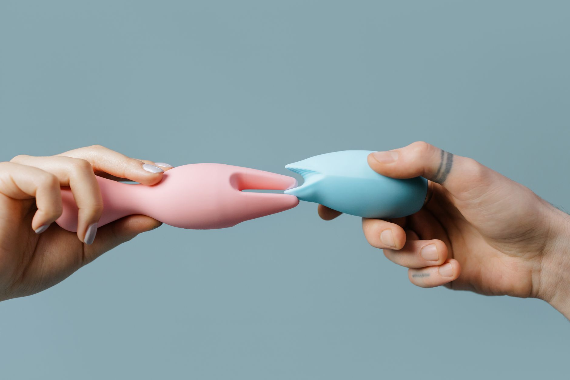 Woman thoughtfully holding a blue silicone vibrator, reflecting on pleasure and connection