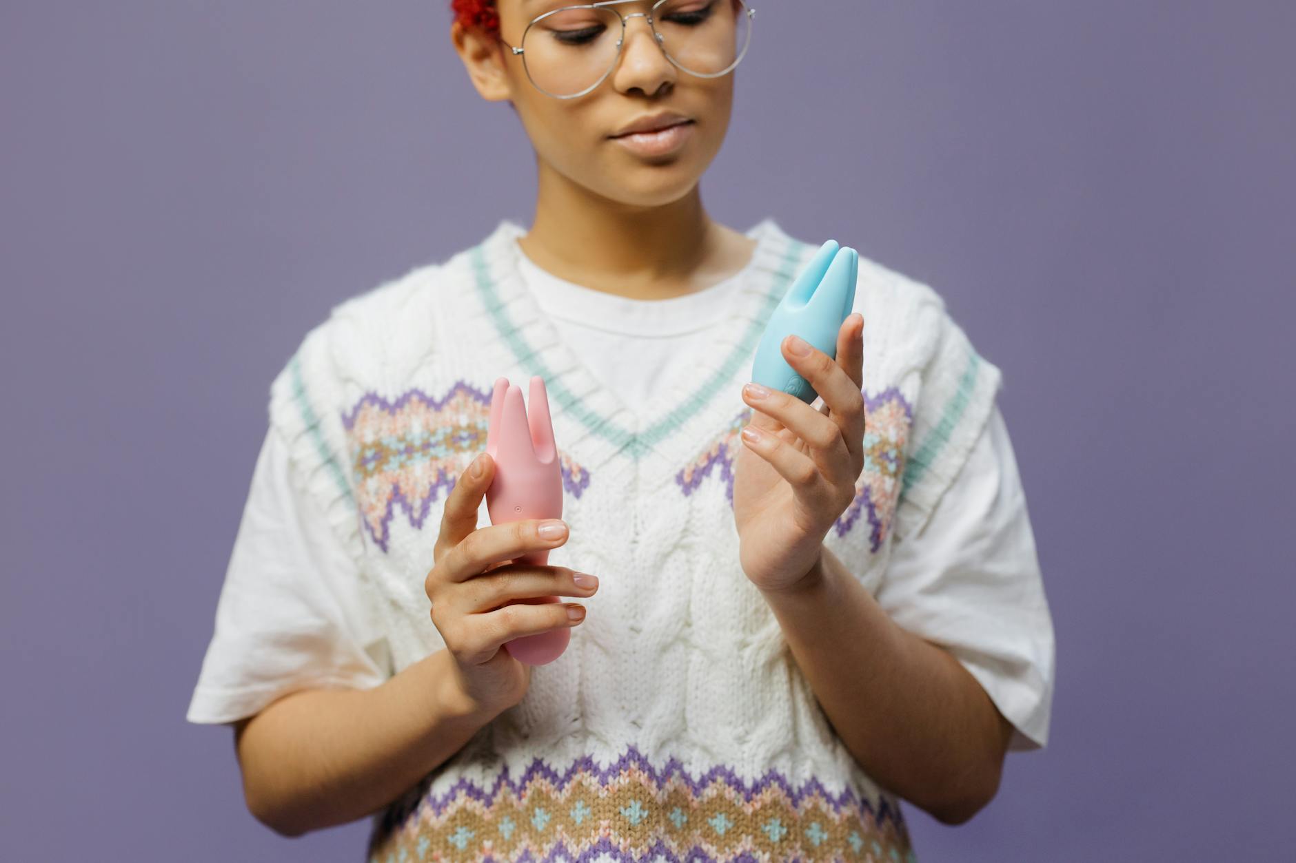 Woman holding blue silicone vibrators, exploring modern intimacy tools